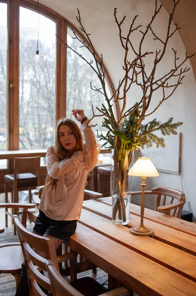 Jeune jolie femme au café. Grunge. Fille dans un café dans un chemisier beige — Photo