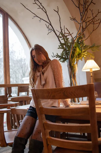 Jeune jolie femme au café. Grunge. Fille dans un café dans un chemisier beige — Photo