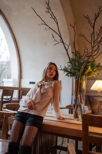 Jeune jolie femme au café. Grunge. Fille dans un café dans un chemisier beige — Photo