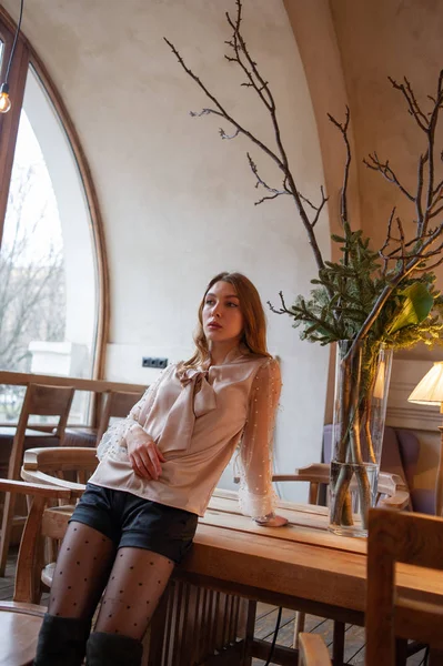 Jeune jolie femme au café. Grunge. Fille dans un café dans un chemisier beige — Photo