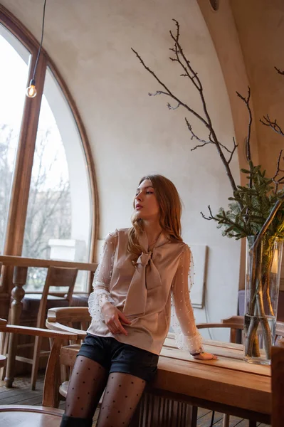 Jeune jolie femme au café. Grunge. Fille dans un café dans un chemisier beige — Photo