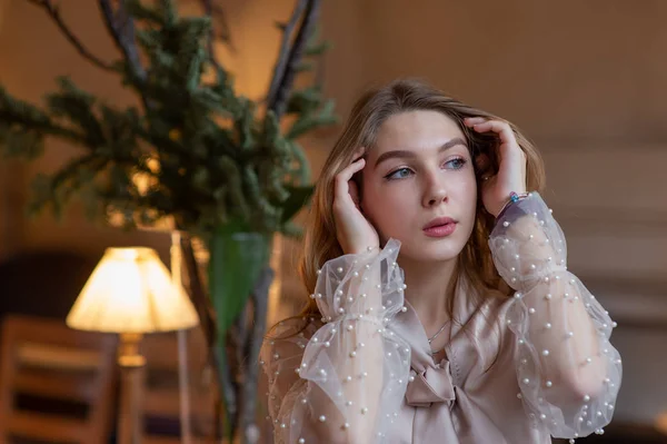 Junge hübsche Frau im Café. Grunge. Mädchen in einem Café in einer beigen Bluse — Stockfoto