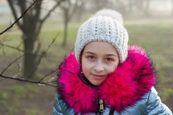 Close-up portret van een mooi negenjarig meisje in het najaarspark. 9 jaar oud meisje met een hoed en een blauwe jas. — Stockfoto