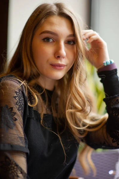 Retrato de una mujer hermosa con vestido negro de moda. Modelo rubio con peinado elegante abrumado por los pensamientos — Foto de Stock