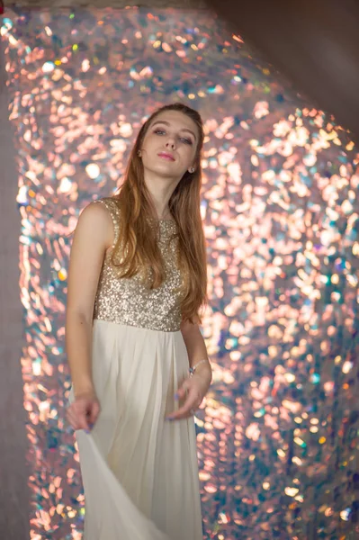 Retrato de beleza de uma menina bonita com um vestido de prata brilhante com maquiagem à noite em um fundo de luzes de Natal. — Fotografia de Stock