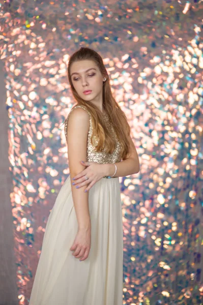 Retrato de beleza de uma menina bonita com um vestido de prata brilhante com maquiagem à noite em um fundo de luzes de Natal. — Fotografia de Stock