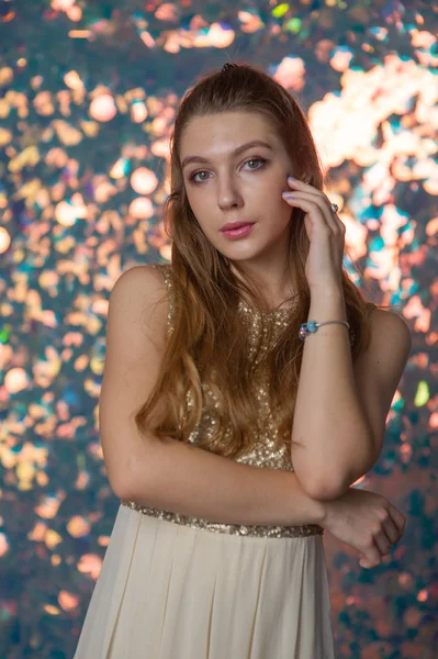 Retrato de beleza de uma menina bonita com um vestido de prata brilhante com maquiagem à noite em um fundo de luzes de Natal. — Fotografia de Stock