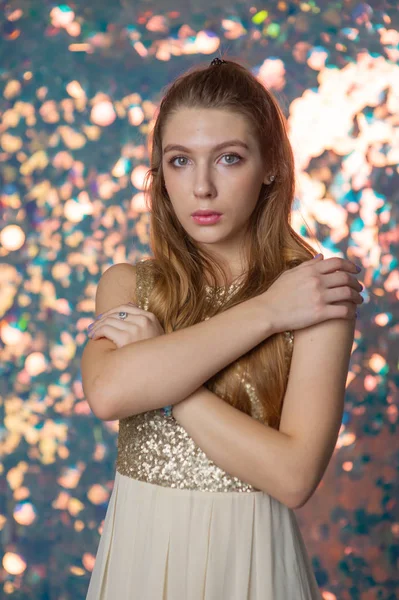 Retrato de belleza de una hermosa chica con un vestido brillante plateado con maquillaje de noche sobre un fondo de luces de Navidad. — Foto de Stock