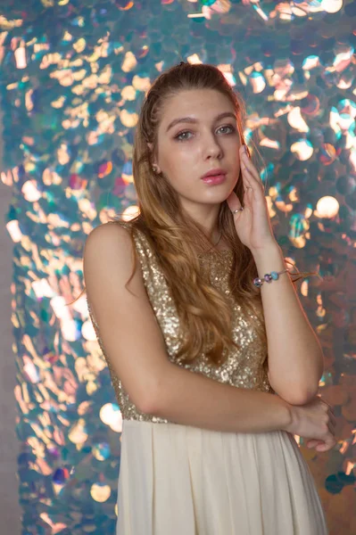 Retrato de belleza de una hermosa chica con un vestido brillante plateado con maquillaje de noche sobre un fondo de luces de Navidad. — Foto de Stock