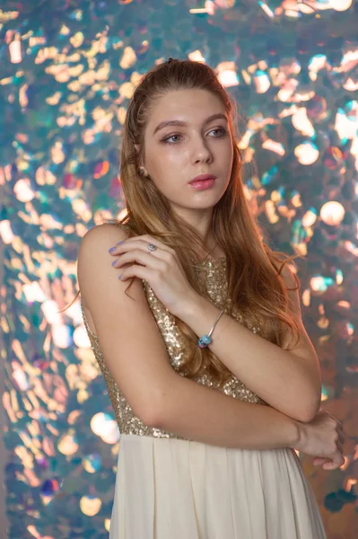 Retrato de belleza de una hermosa chica con un vestido brillante plateado con maquillaje de noche sobre un fondo de luces de Navidad. — Foto de Stock