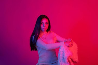 Dolgun doğal dudakları olan muhteşem bir esmer. Stüdyoda renkli filtrelerle uzun pozlar çekiliyor..