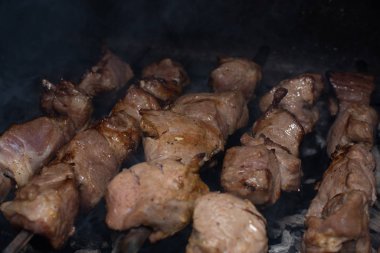 Barbeküde ızgara lezzetli yemeklere yakın çekim. Doğada lezzetli şiş kebap pişirme süreci. Lezzetli yemek.
