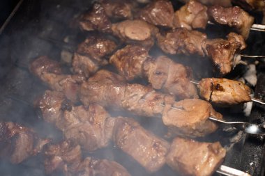 Barbeküde ızgara lezzetli yemeklere yakın çekim. Doğada lezzetli şiş kebap pişirme süreci. Lezzetli yemek.