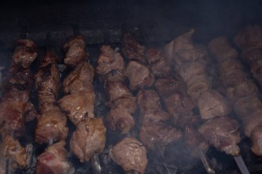 Barbeküde ızgara lezzetli yemeklere yakın çekim. Doğada lezzetli şiş kebap pişirme süreci. Lezzetli yemek.