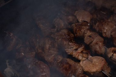 Barbeküde ızgara lezzetli yemeklere yakın çekim. Doğada lezzetli şiş kebap pişirme süreci. Lezzetli yemek.