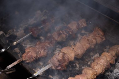 Barbeküde ızgara lezzetli yemeklere yakın çekim. Doğada lezzetli şiş kebap pişirme süreci. Lezzetli yemek.