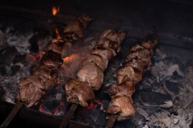 Barbeküde ızgara lezzetli yemeklere yakın çekim. Doğada lezzetli şiş kebap pişirme süreci. Lezzetli yemek.