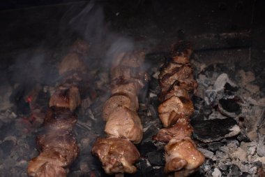 Barbeküde ızgara lezzetli yemeklere yakın çekim. Doğada lezzetli şiş kebap pişirme süreci. Lezzetli yemek.