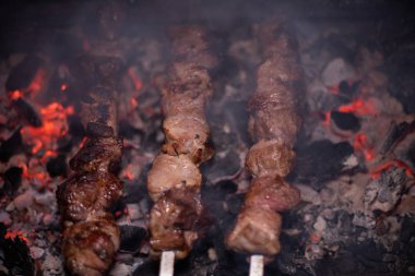 Barbeküde ızgara lezzetli yemeklere yakın çekim. Doğada lezzetli şiş kebap pişirme süreci. Lezzetli yemek.