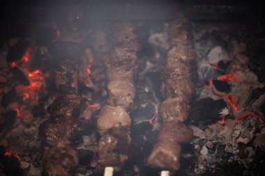 Barbeküde ızgara lezzetli yemeklere yakın çekim. Doğada lezzetli şiş kebap pişirme süreci. Lezzetli yemek.