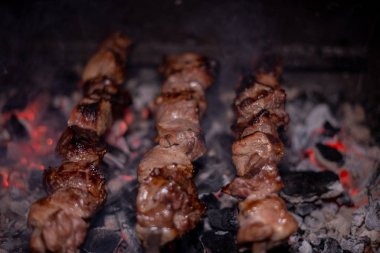 Close-up of grilling tasty dish on barbecue. Process of cooking yummy shashlik in nature. Delicious food clipart