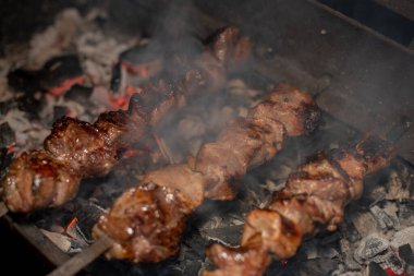 Barbeküde ızgara lezzetli yemeklere yakın çekim. Doğada lezzetli şiş kebap pişirme süreci. Lezzetli yemek.
