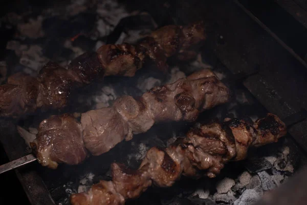 Close-up de grelhar prato saboroso no churrasco. Processo de cozinhar shashlik gostoso na natureza. Comida deliciosa — Fotografia de Stock