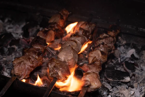 Barbeküde ızgara lezzetli yemeklere yakın çekim. Doğada lezzetli şiş kebap pişirme süreci. Lezzetli yemek.