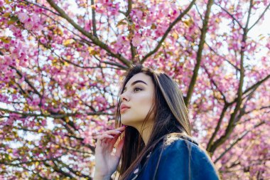 Pembe kiraz çiçekli bir kızla kadınlar günü. Sakura 'daki bir kızla kadınlar günü tatili. Kız ve Sakura..