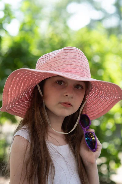 Retrato de mujer bastante alegre con vestido blanco y sombrero rosa de paja en día de clima cálido soleado —  Fotos de Stock