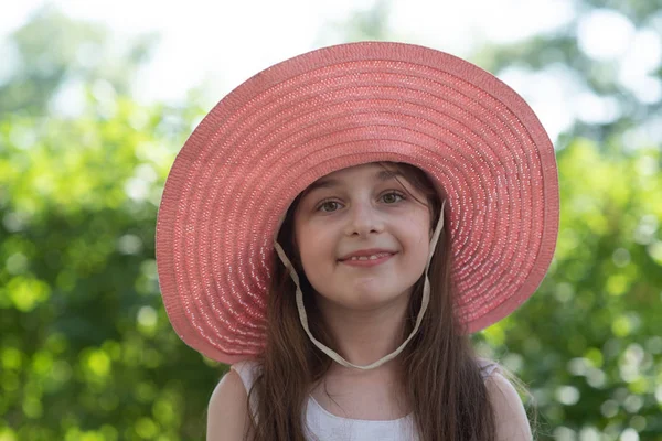 Retrato de mujer bastante alegre con vestido blanco y sombrero rosa de paja en día de clima cálido soleado — Foto de Stock