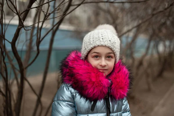 Närbild porträtt av en vacker nioårig flicka i höstparken. 9 år gammal flicka i hatt och blå jacka. — Stockfoto