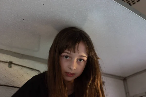 Linda chica acostada en el estante superior en el tren y mirando por la ventana a la calle. Vacaciones de verano —  Fotos de Stock