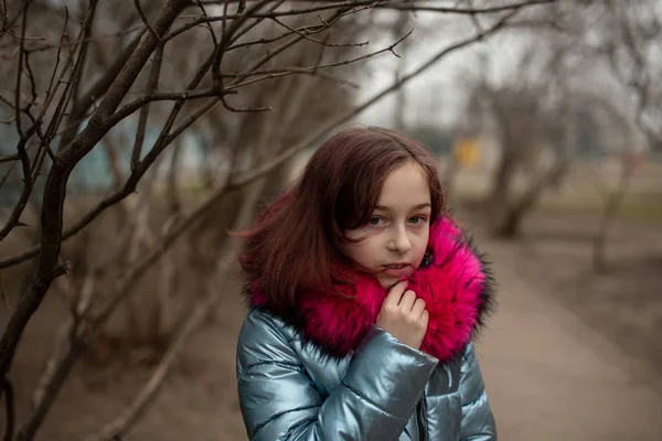 Młoda urocza kobieta w niebieskim wegańskie i sztuczne futro pozuje na tle miasta. Moda modny styl ubrania — Zdjęcie stockowe