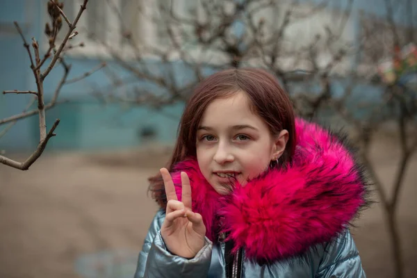 Młoda urocza kobieta w niebieskim wegańskie i sztuczne futro pozuje na tle miasta. Moda modny styl ubrania — Zdjęcie stockowe