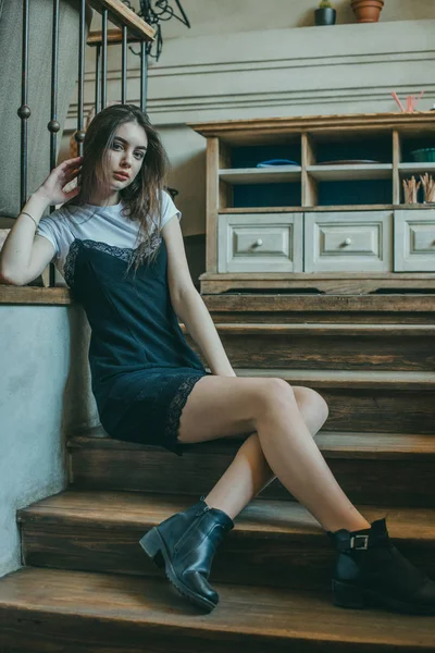 Menina morena elegante bonita vestindo um vestido preto é relaxante em um café de rua. Publicidade, moda. Foto matizada — Fotografia de Stock