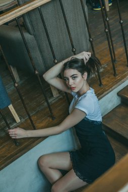 Siyah elbise giyen zarif esmer kız bir sokak kafesinde dinleniyor. Reklamcılık, moda. Renkli fotoğraf