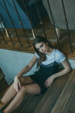 Siyah elbise giyen zarif esmer kız bir sokak kafesinde dinleniyor. Reklamcılık, moda. Renkli fotoğraf