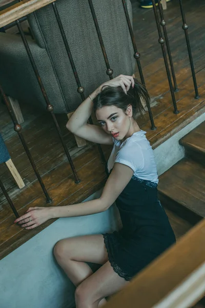 Menina morena elegante bonita vestindo um vestido preto é relaxante em um café de rua. Publicidade, moda. Foto matizada — Fotografia de Stock