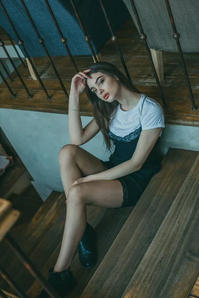 Krásná elegantní brunetka dívka v černých šatech je relaxační v pouliční kavárně. Reklama, móda. Tónovaná fotografie — Stock fotografie