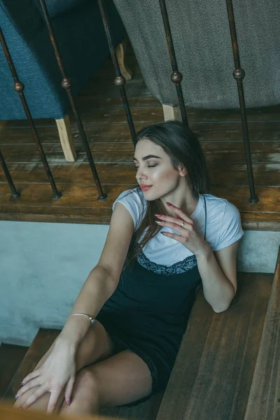 Menina morena elegante bonita vestindo um vestido preto é relaxante em um café de rua. Publicidade, moda. Foto matizada — Fotografia de Stock