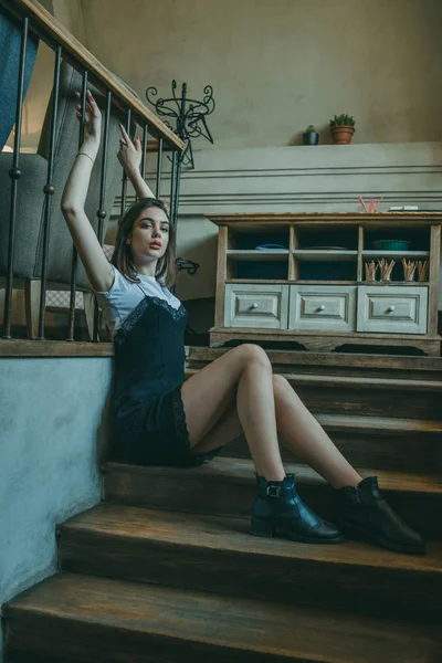 Menina morena elegante bonita vestindo um vestido preto é relaxante em um café de rua. Publicidade, moda. Foto matizada — Fotografia de Stock