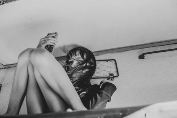 Cute girl lying on the top shelf in the train and looking out the window into the street. Summer Vacation. Tinted photo — Stock Photo, Image