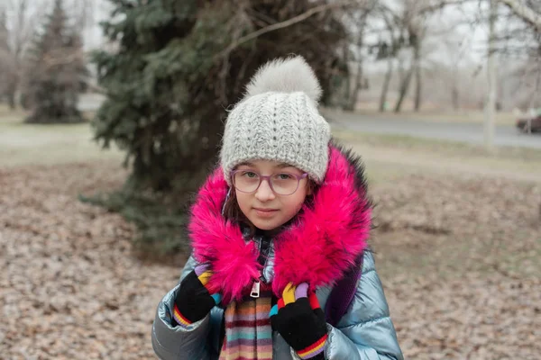 Gros plan portrait d'une belle petite fille de neuf ans dans le parc d'automne. 9 ans fille dans un chapeau et une veste bleue . — Photo