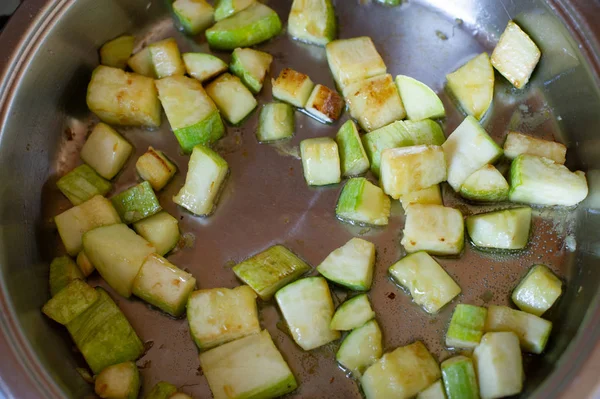 Verduras cortadas en cubos fritos en sartén, en cocina.Calabacín frito en cubos en una sartén — Foto de Stock