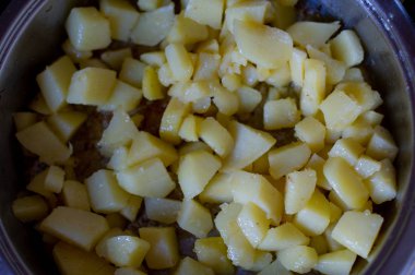 Sebzeler kızartma tavasında, mutfakta küp şeklinde kesilmiş. Tavada kızartılmış patates.