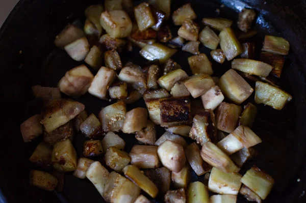Sebzeler kızartma tavasında, mutfakta küp şeklinde kesilmiş. Tavada kızartılmış patlıcan.