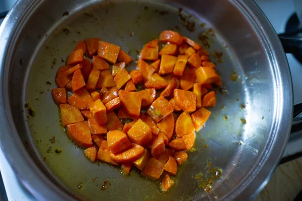 Vegetables cut in cubes fried on frying pan, in kitchen. Carrot fried in cubes in a pan. Carrot — Stock Photo, Image