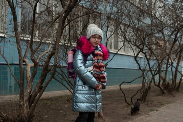 Close up portrait of a beautiful nine year old little girl in autumn park. 9 years old girl in a hat and a blue jacket. — Stock Photo, Image