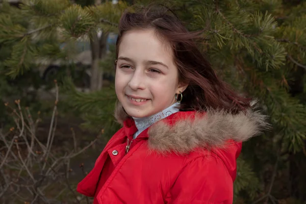 Portrét roztomilé holčičky ve věku 8-9 let, v jasně červené bundě — Stock fotografie